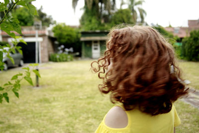 Rear view of woman standing against plants