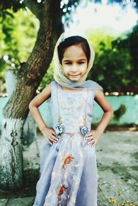 Portrait of a girl standing on tree trunk