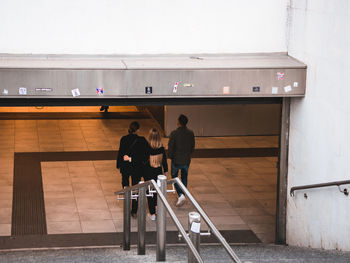 Rear view of people standing against railing
