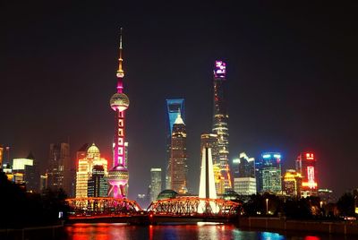Illuminated skyscrapers against sky at night