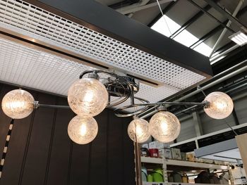 Low angle view of illuminated light bulbs hanging from ceiling