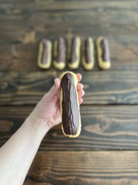 Hand holding a chocolate eclair