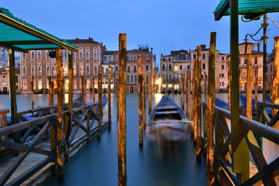 Canal amidst buildings against clear sky at dusk