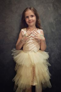 Portrait of smiling girl standing against wall