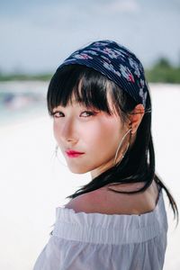 Close-up portrait of beautiful woman standing against sky