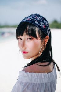 Close-up portrait of beautiful woman standing at beach