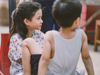 Cute siblings sitting outdoors