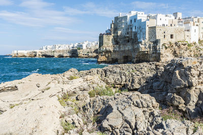 Sea by buildings against sky in city