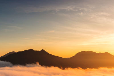 Scenic view of silhouette mountains against sky during sunset