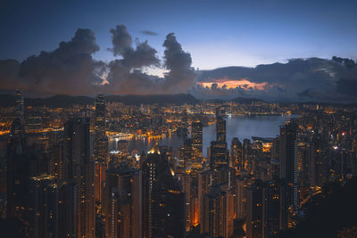 Illuminated modern buildings in city against sky