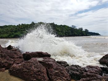 Rocks in sea against sky