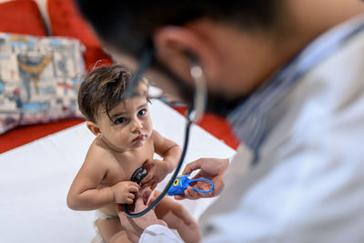 Doctor observing a one-year-old baby