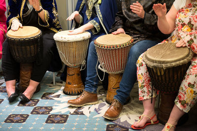 Low section of people playing drum outdoors