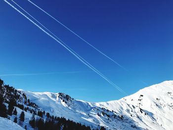 Scenic view of snowcapped mountains against blue sky