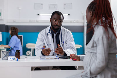 Midsection of female doctor working in office