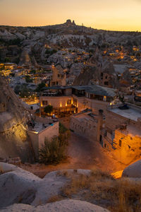 High angle view of illuminated buildings in city at sunset