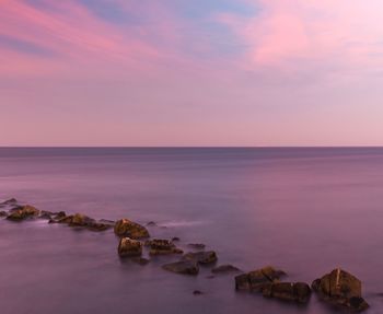 Scenic view of sea against clear sky at sunset