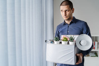 Man holding drink standing at home