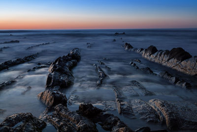 Blurred motion of sea over rocks during sunset