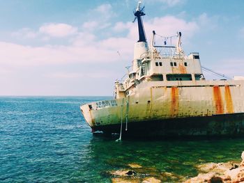 Shipwreck in sea against sky