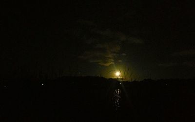 Silhouette landscape against sky at night