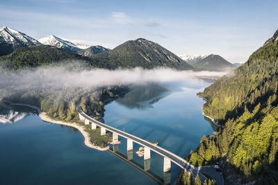 Sylvenstein dam and bridge surrounded by morning mist in winter, sylvensteinsee, lenggries, bavaria, germany