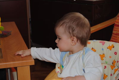 Portrait of cute boy looking at table at home