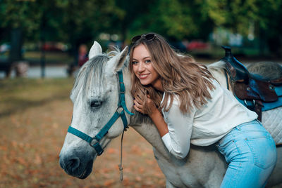 Portrait of woman standing by horse outdoors