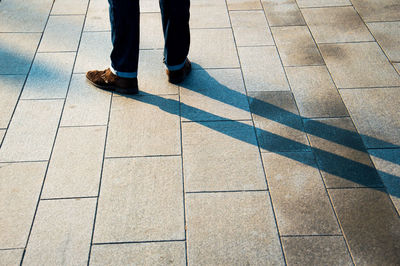 Low section of woman standing on tiled floor