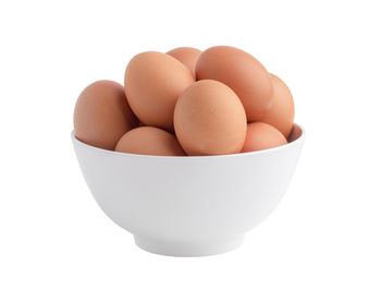 Close-up of eggs in bowl against white background