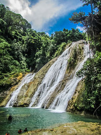 Scenic view of waterfall against sky