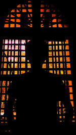 Close-up of silhouette person standing against illuminated building