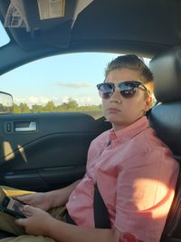 Portrait of boy wearing sunglasses sitting in car
