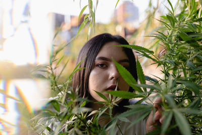 Portrait of young woman amidst plants