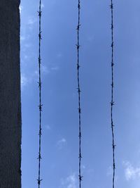 Low angle view of power lines against blue sky