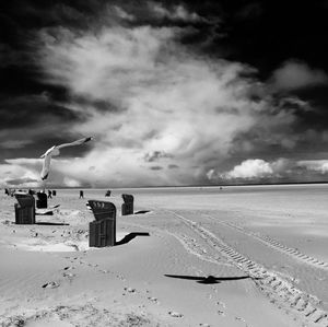 Scenic view of beach against cloudy sky