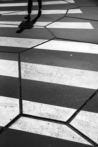 Low section of person walking on zebra crossing