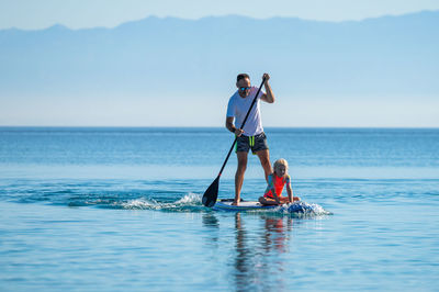 Man surfing in sea against sky