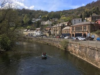 People on boat in river against sky