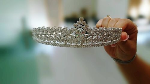 Cropped hand of woman holding crown