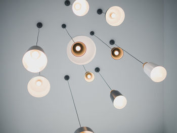 Low angle view of illuminated pendant lights hanging from ceiling