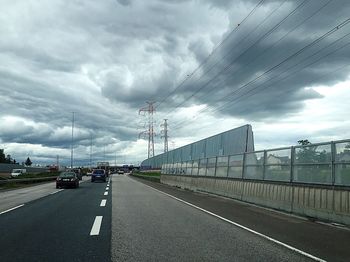 Road leading towards cloudy sky