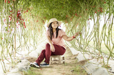 Full length of woman sitting on field