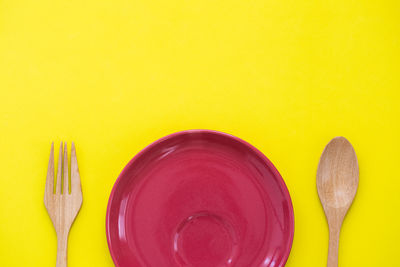 Directly above shot of multi colored pencils on table against yellow background