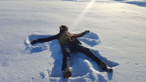 High angle view of man making snow angel