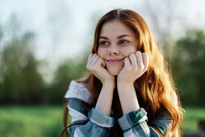 Portrait of young woman sitting on field