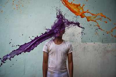 Close-up of paint splashing over man