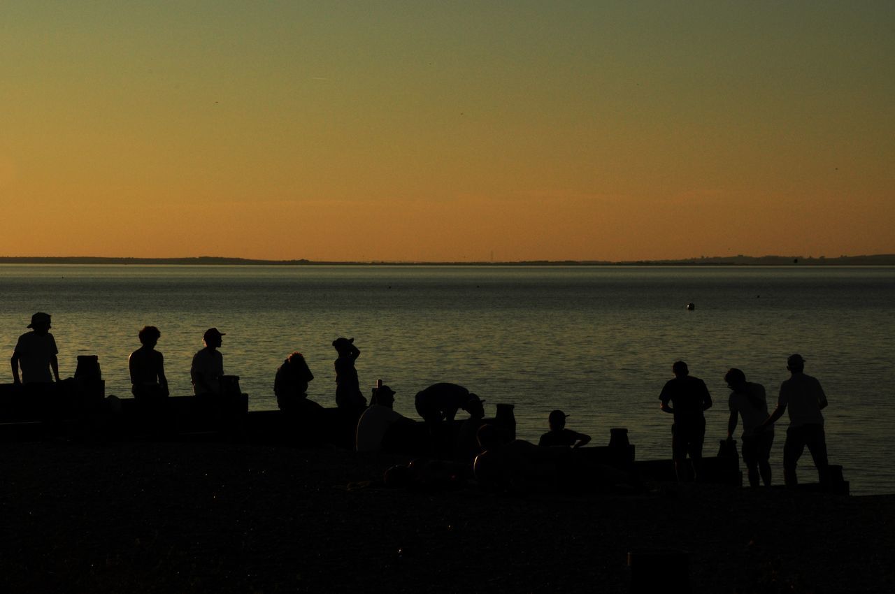 SILHOUETTE PEOPLE AT BEACH DURING SUNSET