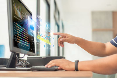 Midsection of man using laptop on table