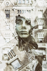 Portrait of statue against building in city